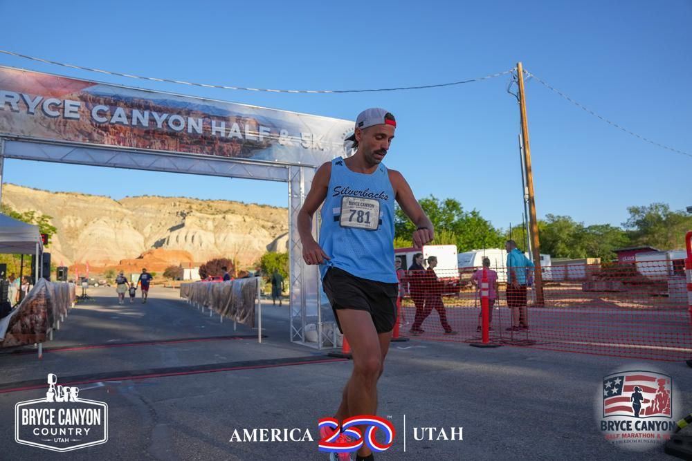 After a race, still in the bib, under a clear sky.